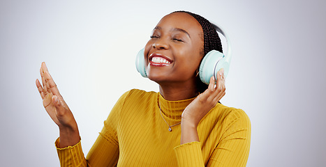 Image showing Jazz, music or headphones with black woman, smile or peace in studio for streaming online radio. Relax, grey background or happy African girl listening to track, song or audio podcast on mobile app