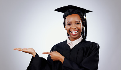 Image showing Graduation, space or portrait of student pointing to education, college or university offer. Smile, black woman or happy graduate in studio for scholarship, promotion or mockup on grey background