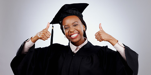 Image showing Graduation, thumbs up and woman or student success with celebration, education and learning or college achievement in studio. Portrait of happy african graduate with like emoji on a white background