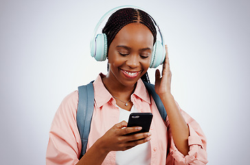 Image showing Woman, student and headphones on mobile for music, elearning audio and education on a white background. Happy african person in backpack and electronics for listening or streaming on phone in studio