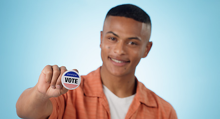 Image showing Man, vote sticker and smile for election, positive and politics for america, government and blue studio background. Badge, voter choice and support for party, registration or hand for voting register