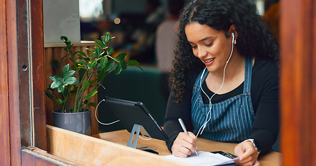 Image showing Waitress, woman and writing in cafe with smile, notebook and music for customer order or sales inventory. Barista, person or employee at store window for service checkout, or working on menu in diner