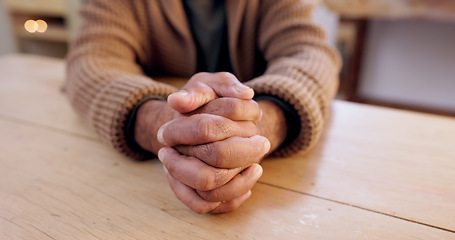Image showing Hands together, person and stress with table and problem from despair and praying. Anxiety, hope and issue in a retirement home with grief, religion and challenge at a house with worry or gratitude