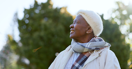 Image showing Happy, thinking and senior woman in a park with a smile for freedom, good mood or positive mindset. Nature, calm and African female person in a forest for travel, adventure or journey in retirement