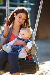 Image showing Woman, baby and swing on park for play, bonding and love with sunshine, child development and care. Mother, kid and infant swinging outdoor in summer for fun, enjoyment and nurture with happiness