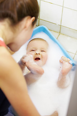 Image showing Baby, mother or play in bathtub for shower, cleaning and hygiene with foam or bubbles for bonding. Child, woman or washing infant in bathroom of home for parenting, development and love with water