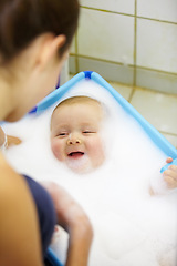Image showing Baby, mother or happy in bathtub for shower, cleaning and hygiene with foam or bubbles for enjoyment. Child, woman or washing infant in bathroom of home for parenting, development and love with water