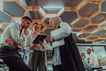 Image showing Young group of business people brainstorming together in a startup space, discussing business projects, investments, and solving challenges.