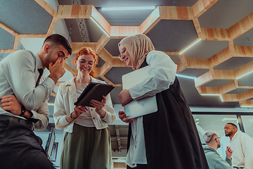 Image showing Young group of business people brainstorming together in a startup space, discussing business projects, investments, and solving challenges.