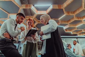 Image showing Young group of business people brainstorming together in a startup space, discussing business projects, investments, and solving challenges.