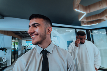 Image showing A group of young business professionals stands together, taking a well-deserved break from their busy workday, showcasing camaraderie, teamwork, and a moment of relaxation in their dynamic workplace