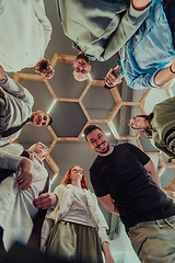 Image showing A group of young businessmen offer their hands together, symbolizing togetherness in the business world