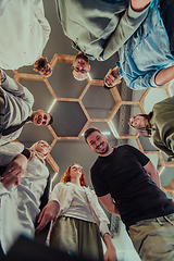 Image showing A group of young businessmen offer their hands together, symbolizing togetherness in the business world