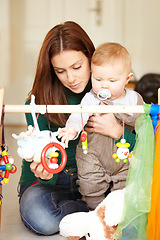 Image showing Mother, baby and playing with toys in living room for childhood development in home. Woman, son and hold with pacifier for care, love and support in bonding, together and future growth with games