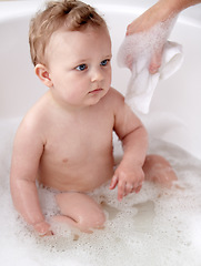 Image showing Baby, bubbles and bath or water cleaning for skin or hair wash for childhood development, hygiene or soap. Child, boy and tub for relax wellness or wet in home for play or cleansing, foam or sanitary