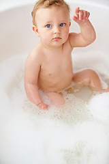 Image showing Baby, face and hand in bubble bath or water cleaning for skin or hair wash for childhood development, hygiene or soap. Child, boy and point in tub for question or confused for cleansing, foam in home