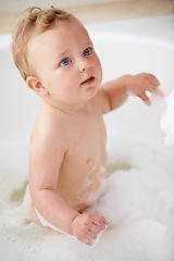 Image showing Baby, bubbles and bath or water cleaning for skin or hair wash for childhood development, hygiene or soap. Child, boy and tub for relax wellness or wet in home for play or cleansing, foam or sanitary