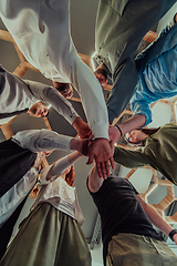 Image showing A group of young businessmen offer their hands together, symbolizing togetherness in the business world