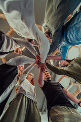 Image showing A group of young businessmen offer their hands together, symbolizing togetherness in the business world