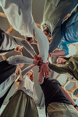 Image showing A group of young businessmen offer their hands together, symbolizing togetherness in the business world