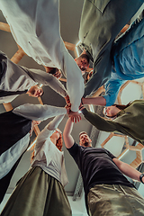 Image showing A group of young businessmen offer their hands together, symbolizing togetherness in the business world