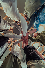 Image showing A group of young businessmen offer their hands together, symbolizing togetherness in the business world