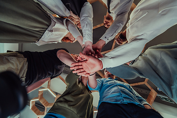 Image showing A group of young businessmen offer their hands together, symbolizing togetherness in the business world