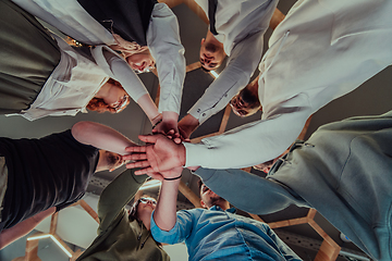 Image showing A group of young businessmen offer their hands together, symbolizing togetherness in the business world