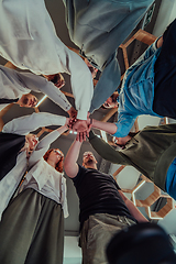 Image showing A group of young businessmen offer their hands together, symbolizing togetherness in the business world