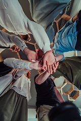 Image showing A group of young businessmen offer their hands together, symbolizing togetherness in the business world