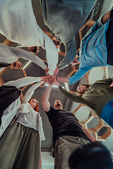 Image showing A group of young businessmen offer their hands together, symbolizing togetherness in the business world