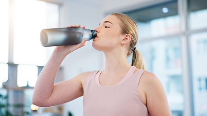 Image showing Woman, home and drink of water for sports break, energy and workout performance. Thirsty athlete, bottle and nutrition of hydration, diet or healthy liquid for training, exercise or fitness in lounge