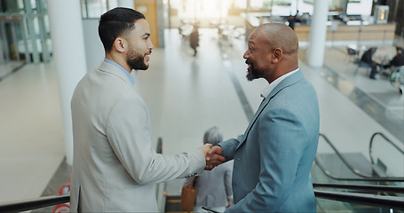 Image showing Happy businessman, handshake and meeting on escalator for partnership, b2b or deal at airport. Business people shaking hands with smile for travel, teamwork or agreement together on moving staircase