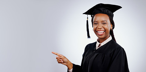 Image showing Graduation student, woman pointing and space for education, learning or college presentation in studio. Portrait of african graduate with information, registration steps or banner on white background