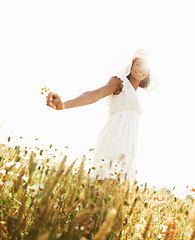 Image showing Portrait, smile and woman in field with flowers in the countryside in summer. Happy person in hat, nature and wheat farm or garden on lens flare, mockup and travel on holiday or vacation in Brazil