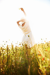 Image showing Freedom, back and woman at wheat field with flower in the countryside in summer, vacation or travel. Rear view, person in hat at farm or nature, garden or outdoor for stretching, lens flare or mockup