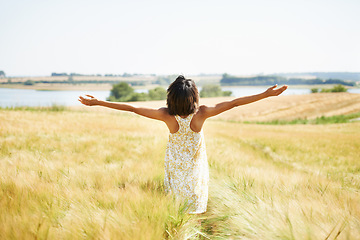 Image showing Back, freedom and woman with open arms at field in the countryside outdoor in summer mockup. Rear view, person in nature and carefree at farm, grass and enjoy fresh air on vacation, holiday or travel