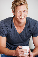 Image showing Portrait, smile and coffee with a man in studio on a gray background to drink a caffeine beverage in the morning. Relax, break and mug with a happy young person drinking tea or feeling satisfied