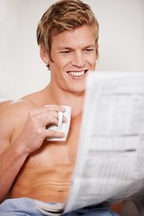 Image showing Bed, coffee and a man reading the newspaper in his home to wake up in the morning after sleep or rest. Smile, tea and media with the body of a shirtless young person in the bedroom of an apartment