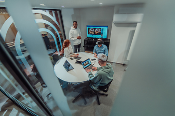 Image showing A diverse group of businessmen collaborates and tests a new virtual reality technology, wearing virtual glasses, showcasing innovation and creativity in their futuristic workspace