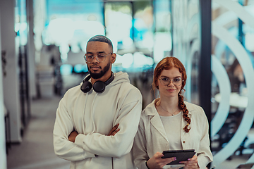 Image showing In a modern office African American young businessman and his businesswoman colleague, with her striking orange hair, engage in collaborative problem-solving sessions