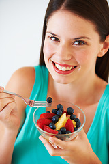 Image showing Health, fruit salad and portrait of woman with berries eating for nutrition, wellness and snack in studio. Food, happy and face of person for vitamins, detox and lose weight on white background