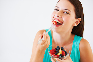 Image showing Fruit salad, happy and portrait of woman in studio eating for nutrition, wellness and snack. Food, balance diet and face of person with berries for vitamins, detox and lose weight on white background