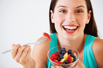 Image showing Diet, fruit salad and portrait of happy woman in studio eating for nutrition, wellness and snack. Food, health and face of person with berries for vitamins, detox and lose weight on white background