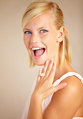Image showing Woman, excited and engagement ring in studio portrait with smile for proposal, wedding or commitment by background. Girl, model and jewelry for marriage, diamond and metal for celebration at ceremony