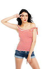 Image showing Fashion, wink and woman face with peace, hands or kiss gesture in studio on white background. V, sign and portrait of lady model with trendy, outfit or thank you, cool or good vibes, emoji or mood