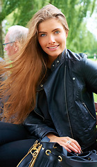 Image showing Outdoor, woman and portrait with fashion with style and trendy clothing with confidence. Park, garden and happy with a smile from female model from Germany with leather jacket and modern bag