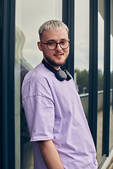 Image showing In front of a modern glass building, a young, blond influencer strikes a confident pose, epitomizing urban glamour and style in the heart of the city