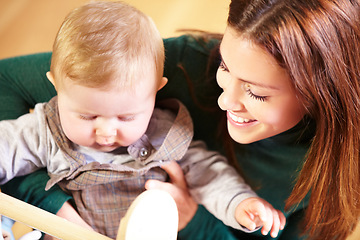 Image showing Mother, holding and baby with smile for child development with toys for future, growth or milestone in home. Woman, infant or family in living room for bond in relationship with love, care or support