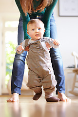 Image showing Mother, baby and face with help for walking in home for motor skills, development or milestone with assistance. Son, toddler and excited for mobility, movement or freedom in living room with support